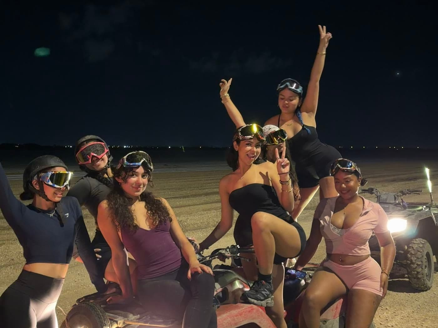A group on lit ATVs on the trail after dark